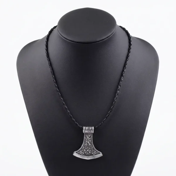Viking axe pendant necklace in stainless steel with intricate Norse knotwork and rune detailing, shown with dimensional measurements (3.6cm x 4cm) and a weight of 17g against an atmospheric Norse warrior background.
